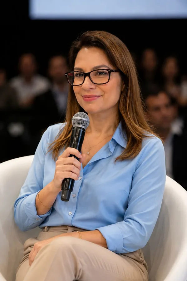 Sônia Gago em painel de evento, com microfone